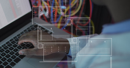 Image of data processing over african american male engineer using laptop at server room. Computer interface and business data storage technology conceptの写真素材