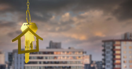 Image of hanging golden house keys against blurred view of tall buildings with copy space. Relocation and real estate conceptの写真素材
