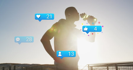 Image of social media icons and numbers over african american male athlete drinking water. Digital...