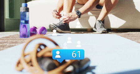 Image of people icon with numbers over african american male athlete tying shoelace. Digital composite, social media, growth, notification, exercise, fitness, hand, leg, preparation.の写真素材
