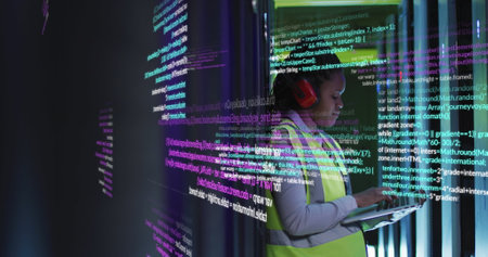 Image of data processing on african american female engineer using laptop working at server room. Computer interface and business data storage technology conceptの写真素材