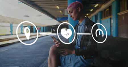 Image of flowchart of icons over biracial woman using phone while waiting for train at station....