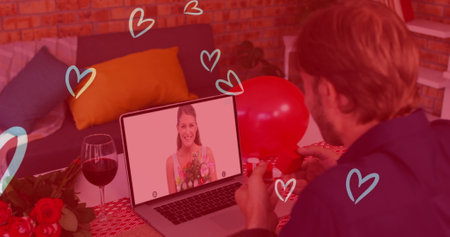 Caucasian couple is enjoying virtual date, man holding a red balloon. He has light brown hair, wearing a casual shirt; she smiles from laptop screenの写真素材