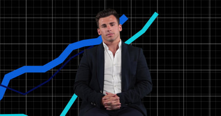 Caucasian young adult professional wearing black suit, sitting with short brown hair. Looking directly at camera, exuding confidence and professionalismの写真素材