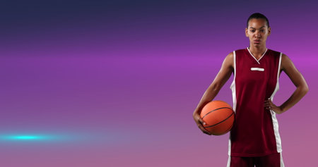Image of female basketball player holding ball over glowing pink background. sports and competition concept digitally generated image.の写真素材