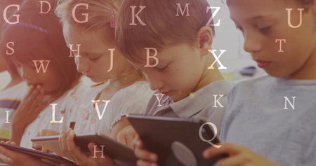 Image of letters over happy school children using tablets. children's book day, reading and education concept digitally generated image.の写真素材