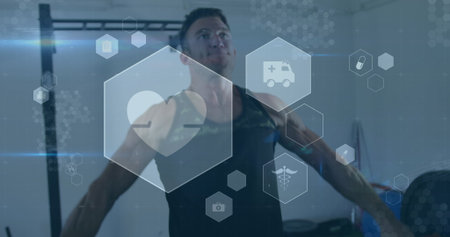 Image of medical and health icons over caucasian man exercising in gym. active healthy lifestyle and...