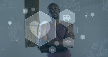 Image of medical and health icons over african american man exercising in gym. active healthy lifestyle and sports concept digitally generated image.の写真素材