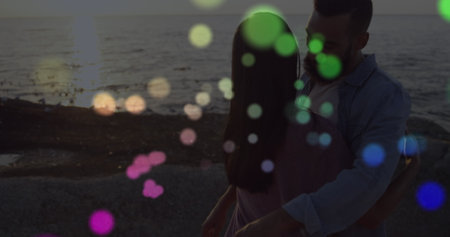 Image of spots over diverse couple embracing. Free time and digital interface concept digitally...