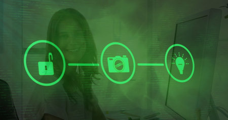 Image of tech icons over caucasian woman working on computer. Business, network, connections, communication and technology concept digitally generated image.の写真素材