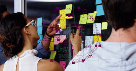 Image of data processing over diverse business people taking notes on glass wall. Global business...