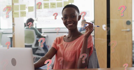 Image of question marks over african american businesswoman working at office. Global business, finances and digital interface concept digitally generated image.の写真素材