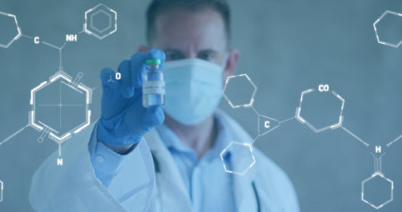 Image of chemical structures over caucasian male doctor holding vaccine wearing face mask. Global...