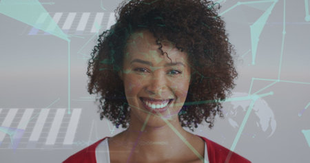 Image of network of connections with icons over biracial woman smiling at camera. global connections, technology and digital interface concept digitally generated image.の写真素材