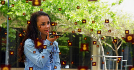 Image of icons connected with lines over biracial woman talking on speaker of cellphone. Digital...
