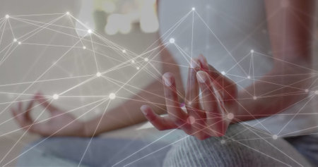 Image of network over midsection of african american woman practicing yoga meditation. Lotus position, meditation, wellbeing, connection and communication, digitally generated image.の写真素材