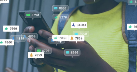 Image of social media notifications over happy african american woman using smartphone in city....