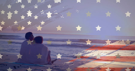 Image of american flag over happy diverse couple wrapped in rug embracing sat on sunset beach. America, summer, vacations, romance, love, celebration and patriotism, digitally generated image.の写真素材