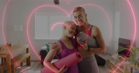 Image of hearts over diverse female couple with yoga mats. Pride, lifestyle and celebration concept digitally generated image.の写真素材