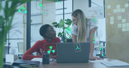 Image of ecology icons over diverse colleagues using laptop and discussing work in office. Global...