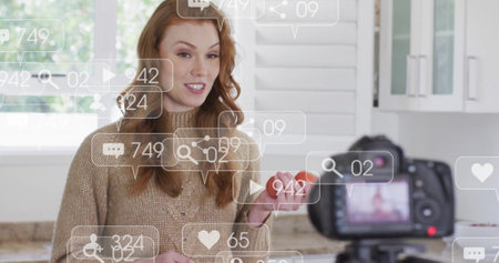 Social media notifications image over woman holding tomato and smiling at cameraの写真素材