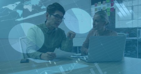 Business data analytics image over colleagues discussing documents in office