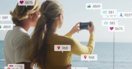 Taking photo by sea, couple surrounded by social media notifications image