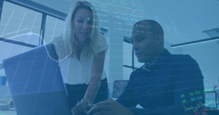 Financial data and stock market image over business professionals working on laptop