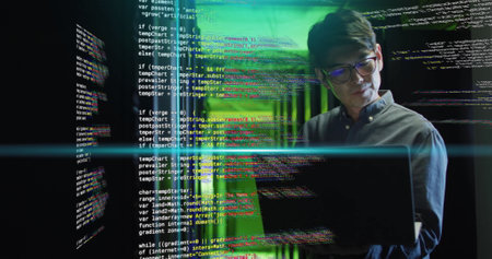 Working on laptop, man in server room with coding image over green lightの写真素材