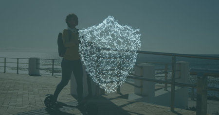 Image of digital shield over african american woman with scooter. global business and digital...