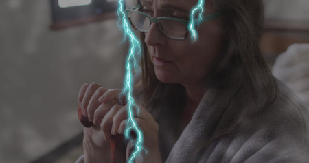 Image of lightning over sad senior caucasian woman with cane. mental health awareness week and...