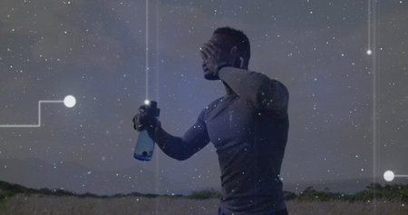Image of connecting dots over african american fit man pouring water on his face outdoors. Sports and fitness technology conceptの写真素材