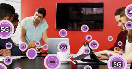 Image of 5g text and symbols in circles over diverse coworkers sharing ideas in office. Digital composite, multiple exposure, business, planning, teamwork, telecommunication and technology.の写真素材