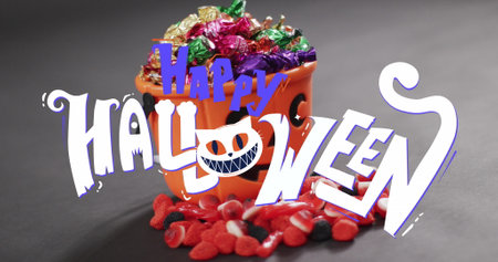 Image of happy halloween text over orange pumpkin bucket with sweets. halloween tradition and...