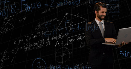 Mathematical equations floating against caucasian businessman using laptop against black background....