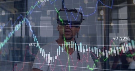 African American male wearing virtual reality headset, looking at data. He has short black hair,...