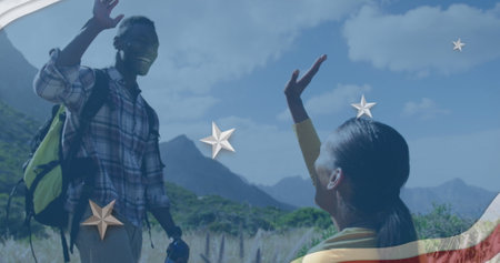 Image of american flag over african american couple high fiving in mountains. patriotism and...