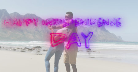 Image of text independence day over african american couple dancing at beach. patriotism and...
