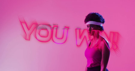 Image of you win text, neon pattern african american female tennis player. Global sports, image game, digital interface, communication, data processing concept digitally generated image.の写真素材