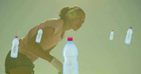 Image of ecology icons over african american female volunteer segregating waste. Recycle week, ecology and celebration concept digitally generated image.の写真素材