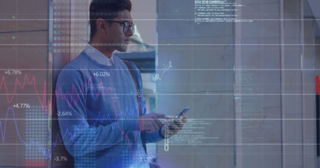 Image of binary codes, computer language, biracial man standing and scrolling on cellphone. Graphs,...