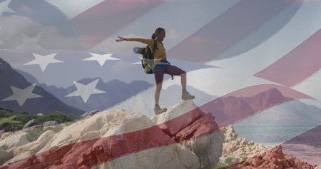 Biracial woman on rock with American flag.. She has brown skin, dark hair, and is wearing casual clothesの写真素材
