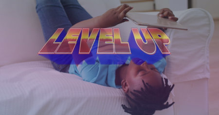 Image of level up text over african american boy using tablet. communication technology and online...