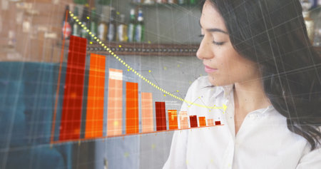 Image of financial data processing over caucasian businesswoman using laptop. Global finance,...