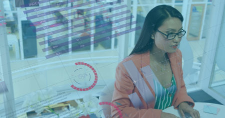 Image of financial data processing over asian businesswoman in office. Global finance, business, connections, computing and data processing concept digitally generated image.の写真素材