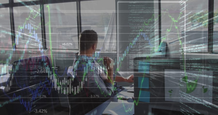 Image of financial data over caucasian businessman working on laptop in office. economy, finance,...