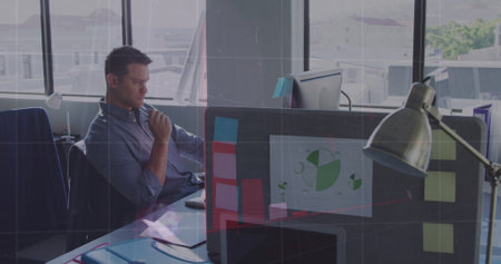 Image of financial data over caucasian businessman working on laptop in office. economy, finance,...