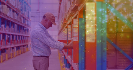 Image of glowing spots of light over caucasian man carrying box working in warehouse,. global...