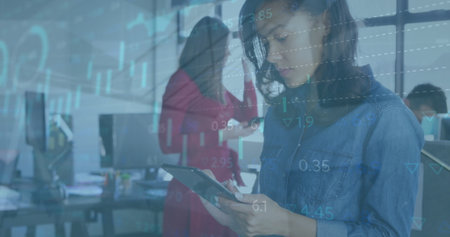 Image of statistics and financial data processing over businesswoman using tablet in office. Global...