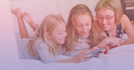 Three caucasian sisters using smartphone together while lying on the bed. national siblings day...